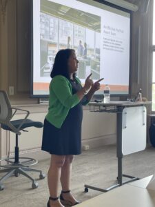 Kris Monahan presents to research administration professionals during a RIRAC workshop at Salve Regina University. Participants are seated throughout the room, viewing a projected presentation focused on strengthening collaboration across research administration services.